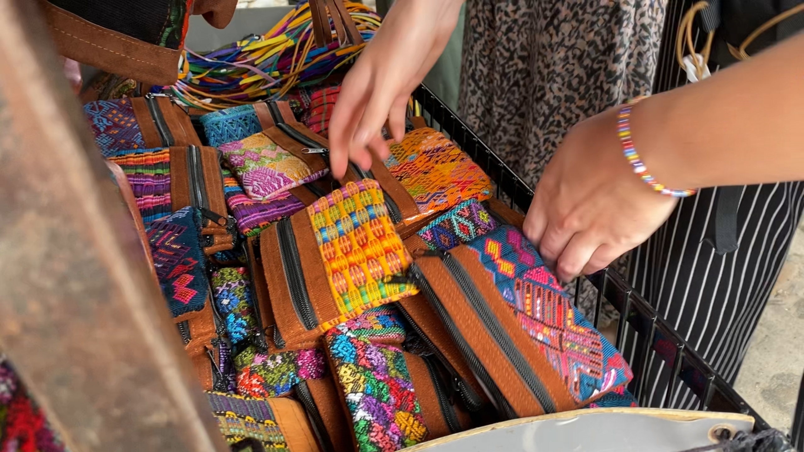 Vrouw pakt kleurrijk, traditioneel portefeuille op marktje